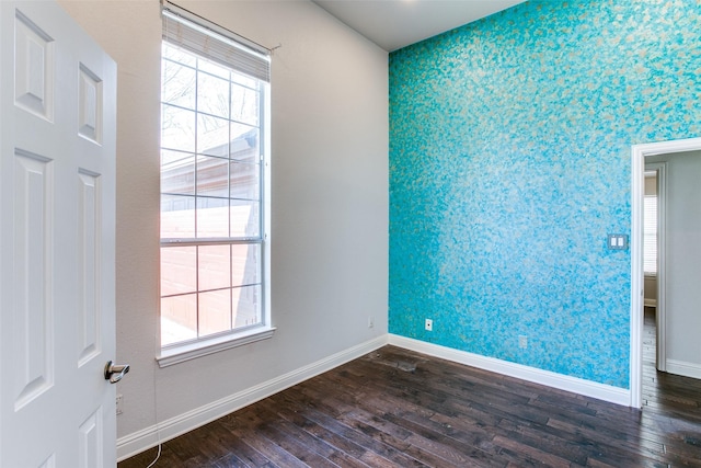 6004 Grand Meadow Ln, Flower Mound, TX 75028 - empty room with an accent wall, wallpapered walls, baseboards, dark wood-style flooring, and plenty of natural light