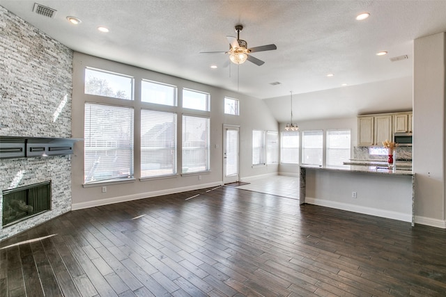 6004 Grand Meadow Ln, Flower Mound, TX 75028 - unfurnished living room with ceiling fan, a fireplace, a chandelier, dark wood-type flooring, and a textured ceiling