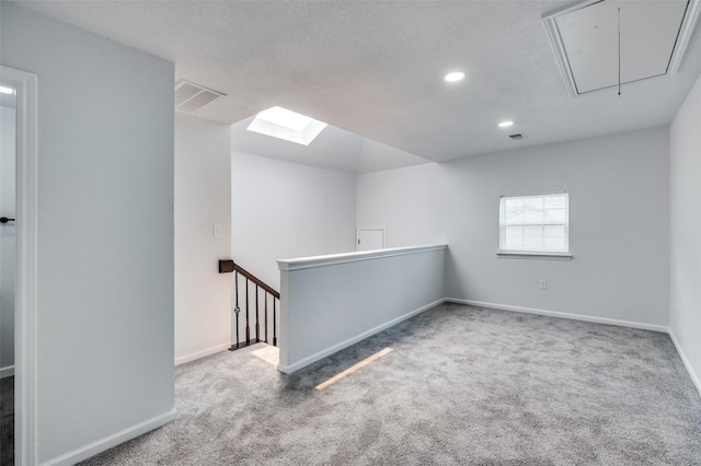 7708 Partridge Dr, Watauga, TX 76148 - carpeted spare room with attic access, baseboards, recessed lighting, and a skylight
