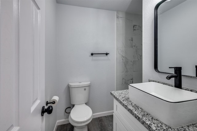 7708 Partridge Dr, Watauga, TX 76148 - bathroom featuring toilet, vanity, wood finished floors, and baseboards