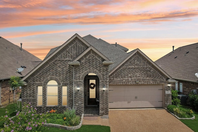 16001 Gladewater Ter, Prosper, TX 75078 - french country inspired facade with brick siding, a shingled roof, a garage, driveway, and central AC