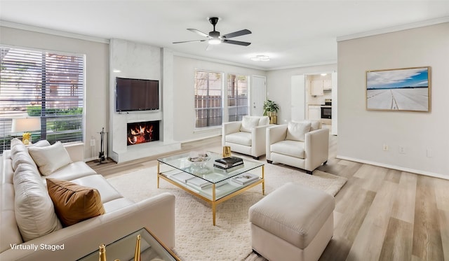 10578 High Hollows Dr Unit 166, Dallas, TX 75230 - living area with ornamental molding, a large fireplace, light wood-type flooring, ceiling fan, and baseboards