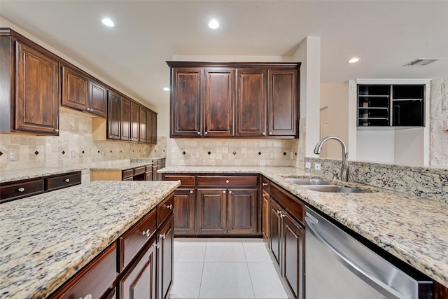 9122 Bottlebrush Ln, Irving, TX 75063 - kitchen with stainless steel dishwasher, a sink, light stone counters, dark brown cabinets, and recessed lighting