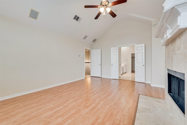 9122 Bottlebrush Ln, Irving, TX 75063 - unfurnished living room with a ceiling fan, a tiled fireplace, light wood-style flooring, high vaulted ceiling, and baseboards
