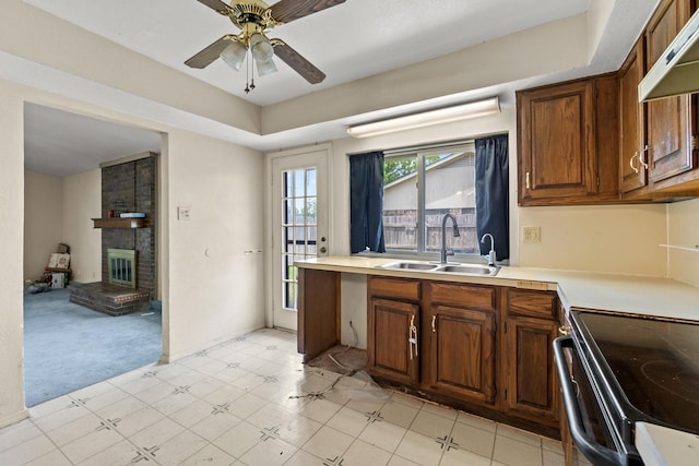 4006 Fletcher Dr, Garland, TX 75044 - kitchen featuring a sink, a brick fireplace, light countertops, ceiling fan, and under cabinet range hood