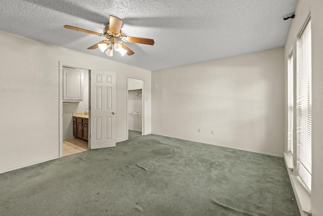 4006 Fletcher Dr, Garland, TX 75044 - unfurnished bedroom with light colored carpet, a textured ceiling, a spacious closet, connected bathroom, and a ceiling fan