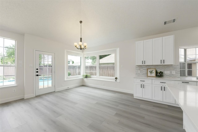 811 Chittamwood Ln, Allen, TX 75002 - kitchen with a chandelier, light countertops, white cabinetry, and light wood-style floors