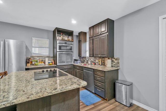 5340 Bourquin St, Dallas, TX 75210 - kitchen featuring stainless steel dishwasher, black electric stovetop, light wood-style floors, backsplash, and a sink