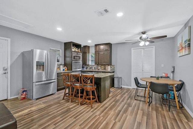 5340 Bourquin St, Dallas, TX 75210 - kitchen with appliances with stainless steel finishes, baseboards, light wood finished floors, a center island, and a ceiling fan