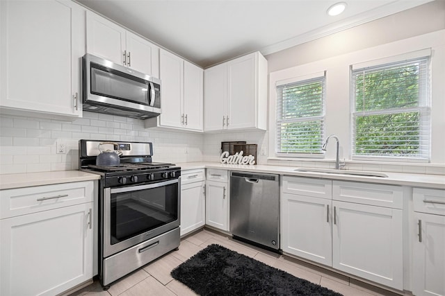 4742 Victor St, Dallas, TX 75246 - kitchen with stainless steel appliances, light countertops, a sink, ornamental molding, and recessed lighting