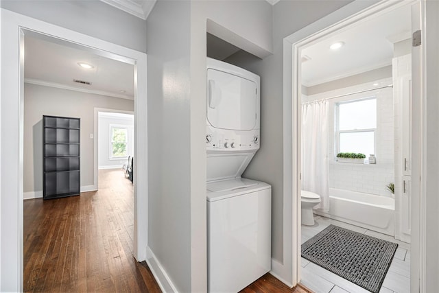4742 Victor St, Dallas, TX 75246 - washroom featuring stacked washer / dryer, crown molding, dark wood-style floors, baseboards, and recessed lighting