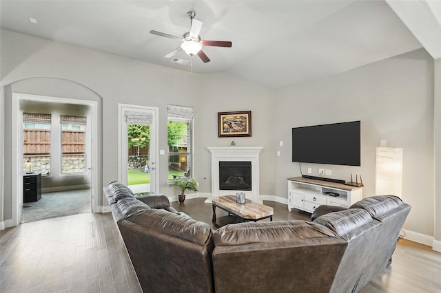 7817 Fossil Creek Trl, Mckinney, TX 75071 - living area with ceiling fan, wood finished floors, baseboards, a glass covered fireplace, and vaulted ceiling