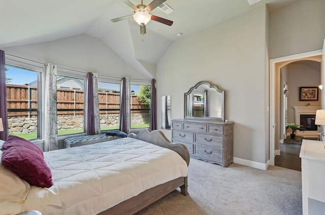 7817 Fossil Creek Trl, Mckinney, TX 75071 - bedroom with multiple windows, vaulted ceiling, light carpet, baseboards, and a glass covered fireplace