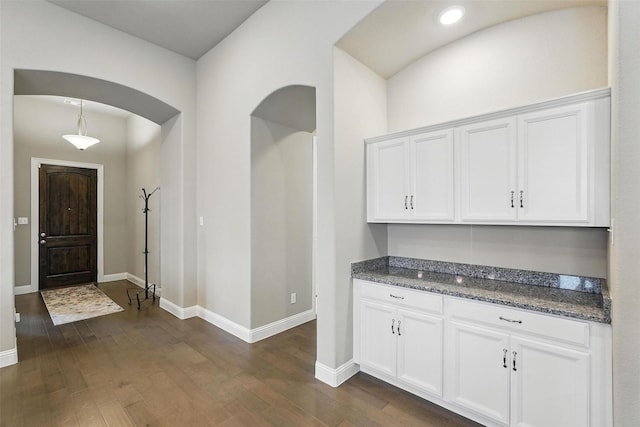 7817 Fossil Creek Trl, Mckinney, TX 75071 - kitchen with white cabinets, arched walkways, dark wood finished floors, baseboards, and recessed lighting