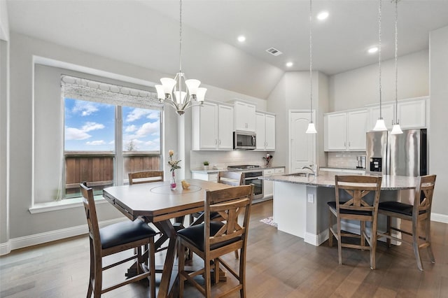 7817 Fossil Creek Trl, Mckinney, TX 75071 - dining space with baseboards, dark wood-style floors, recessed lighting, a chandelier, and high vaulted ceiling
