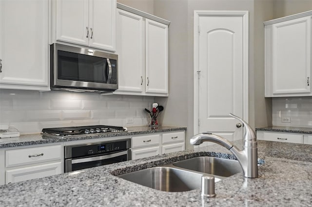 7817 Fossil Creek Trl, Mckinney, TX 75071 - kitchen with appliances with stainless steel finishes, a sink, white cabinets, tasteful backsplash, and light stone counters