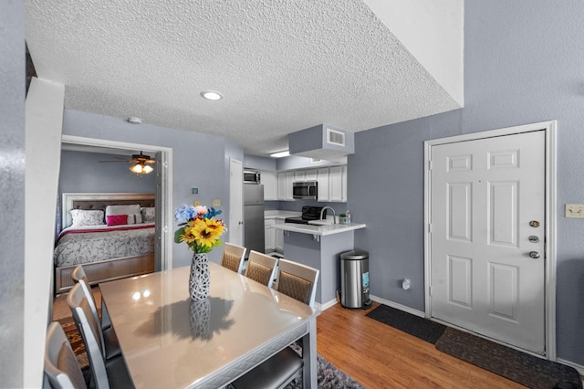 9815 Walnut St Unit 204, Dallas, TX 75243 - dining room with wood finished floors, a textured ceiling, and ceiling fan