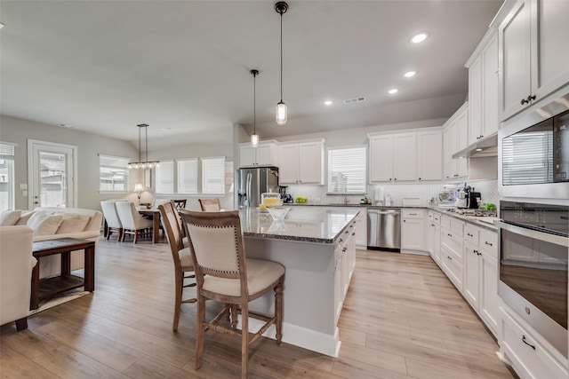 2208 Clancy Dr, Northlake, TX 76247 - kitchen featuring appliances with stainless steel finishes, recessed lighting, a kitchen island, a kitchen bar, and white cabinetry