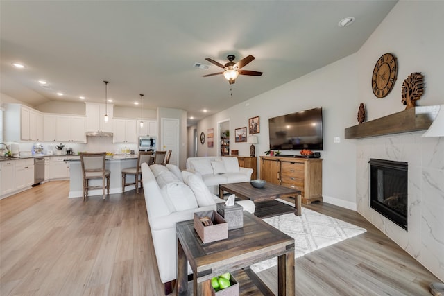 2208 Clancy Dr, Northlake, TX 76247 - living area with a ceiling fan, light wood-style floors, lofted ceiling, a tile fireplace, and recessed lighting