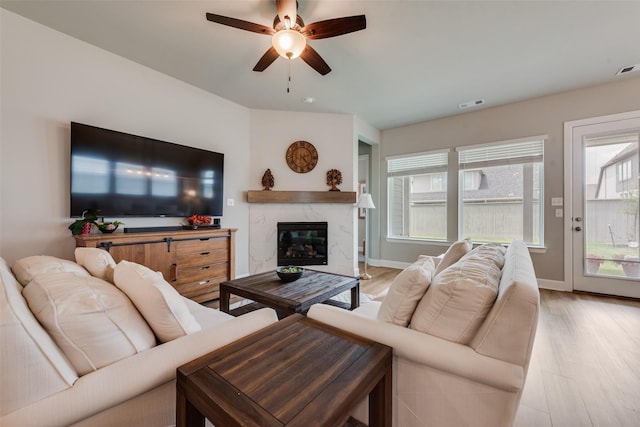 2208 Clancy Dr, Northlake, TX 76247 - living room with ceiling fan, light wood-type flooring, a premium fireplace, and baseboards