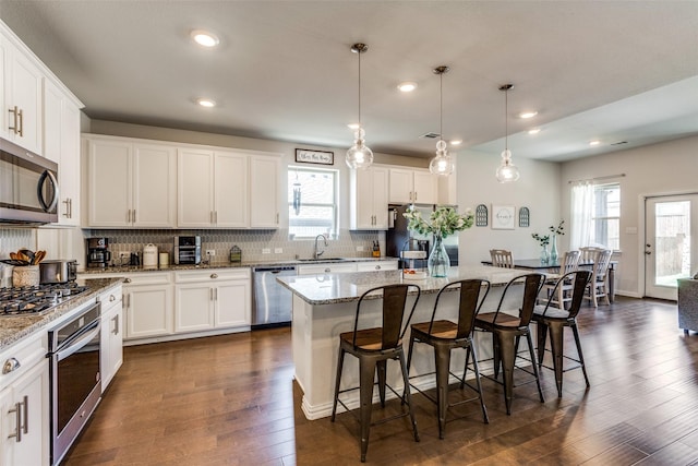 1312 Hutchings Ct, Celina, TX 75009 - kitchen with stainless steel appliances, a sink, backsplash, white cabinets, and recessed lighting