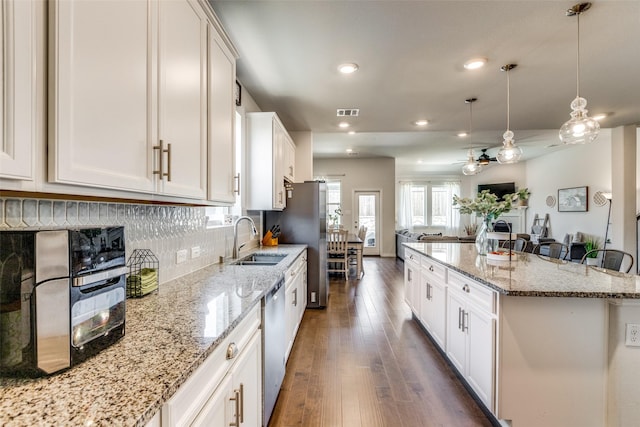 1312 Hutchings Ct, Celina, TX 75009 - kitchen with a sink, dishwasher, dark wood finished floors, open floor plan, and recessed lighting