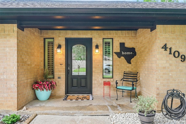4109 Three Oaks Dr, Arlington, TX 76016 - doorway to property with a shingled roof, brick siding, and a porch