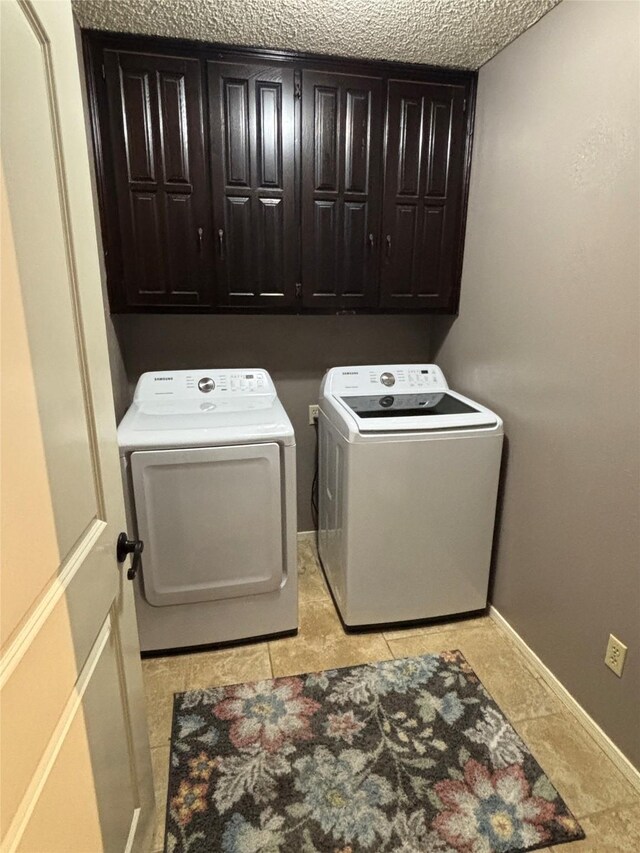 4109 Three Oaks Dr, Arlington, TX 76016 - laundry room featuring washer and clothes dryer, cabinet space, light tile patterned floors, and baseboards