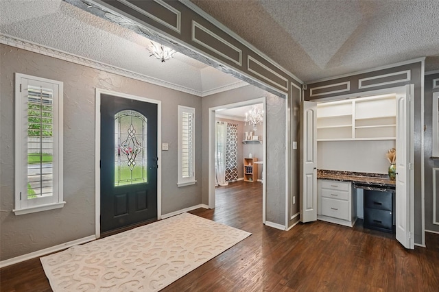 4109 Three Oaks Dr, Arlington, TX 76016 - entryway with a chandelier, a textured ceiling, dark wood-type flooring, a textured wall, and crown molding
