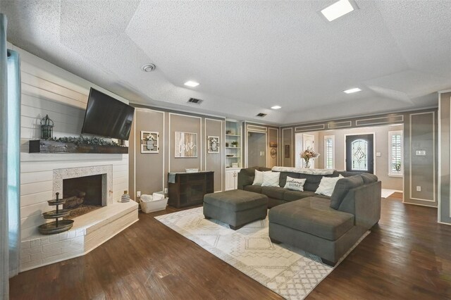 4109 Three Oaks Dr, Arlington, TX 76016 - living area with a textured ceiling, dark wood finished floors, and a fireplace with raised hearth
