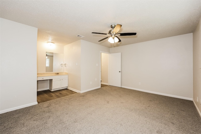 1421 Monica Ct, Mesquite, TX 75149 - unfurnished bedroom with dark carpet, baseboards, connected bathroom, and ceiling fan