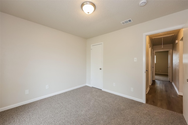 1421 Monica Ct, Mesquite, TX 75149 - spare room with attic access, dark colored carpet, a smoke detector, baseboards, and a textured ceiling