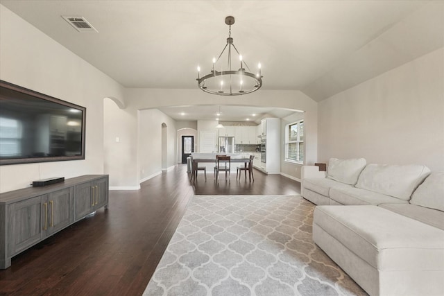 2205 Perrymead Dr, Forney, TX 75126 - living area featuring arched walkways, dark wood-style floors, and a chandelier
