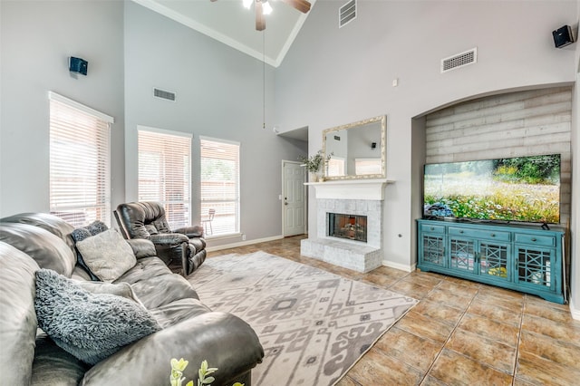 11543 Las Polamas Dr, Frisco, TX 75033 - tiled living area with ceiling fan, ornamental molding, baseboards, a fireplace with raised hearth, and high vaulted ceiling