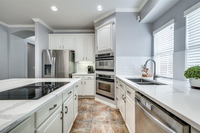 11543 Las Polamas Dr, Frisco, TX 75033 - kitchen with stainless steel appliances, a sink, crown molding, white cabinets, and light stone counters
