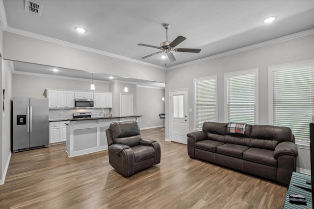 2939 Meadow Brook Trl, Tyler, TX 75701 - living area featuring ceiling fan, wood finished floors, baseboards, recessed lighting, and crown molding