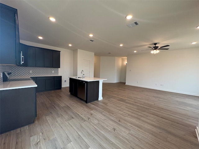 4049 Rimfire Rd, Waco, TX 76705 - kitchen with ceiling fan, a sink, light countertops, open floor plan, and light wood-style floors