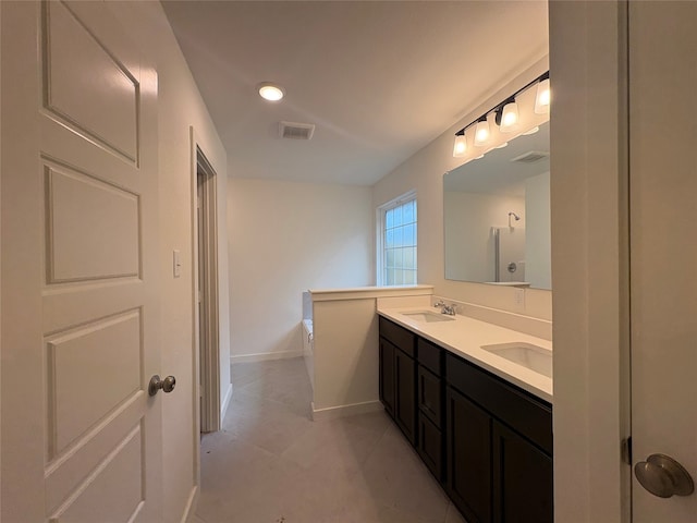 4049 Rimfire Rd, Waco, TX 76705 - bathroom featuring double vanity, baseboards, tile patterned flooring, and recessed lighting
