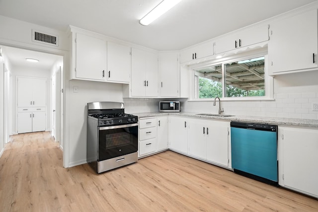 1942 Woodard St, Abilene, TX 79605 - kitchen with stainless steel appliances, a sink, light wood finished floors, and decorative backsplash