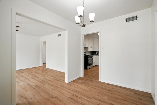 1942 Woodard St, Abilene, TX 79605 - unfurnished room with a chandelier, light wood-style floors, and baseboards
