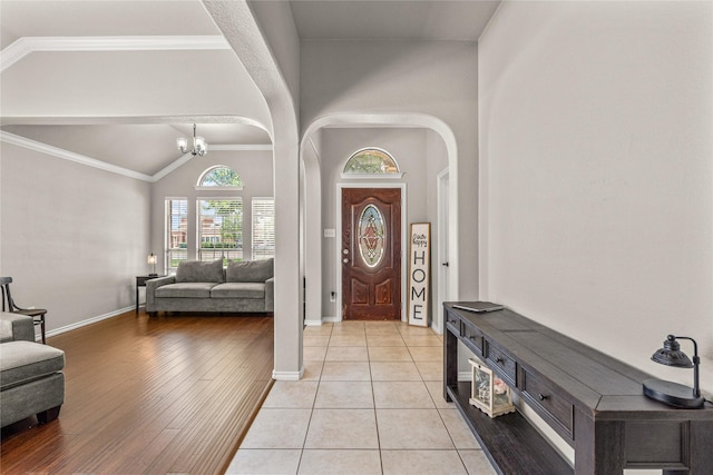 1917 Winter Hawk Dr, Fort Worth, TX 76177 - entrance foyer with arched walkways, baseboards, a chandelier, high vaulted ceiling, and light wood-style flooring