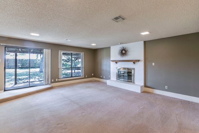 1604 Oak Hollow Dr, Woodway, TX 76712 - unfurnished living room featuring light colored carpet, baseboards, a textured ceiling, and a fireplace