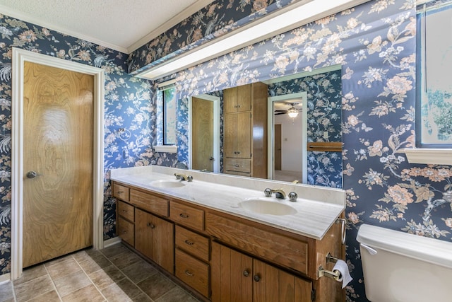 1604 Oak Hollow Dr, Woodway, TX 76712 - full bathroom with double vanity, a textured ceiling, crown molding, and toilet