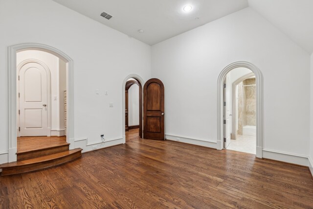 44 Armstrong Dr, Frisco, TX 75034 - spare room featuring arched walkways, lofted ceiling, wood finished floors, and stairway