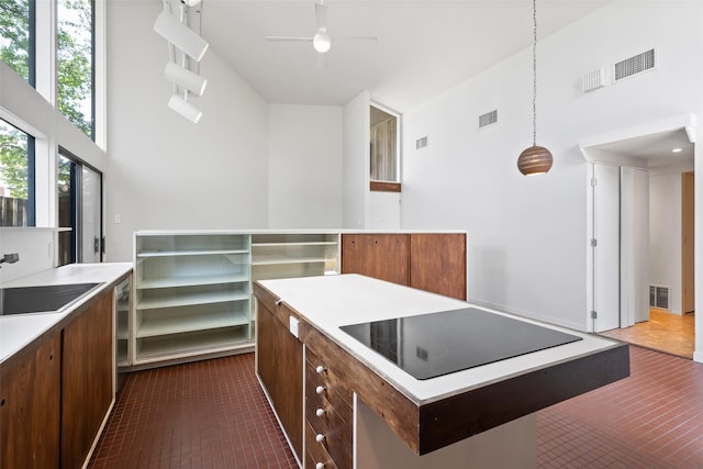 1703 E Barbara St, Tyler, TX 75701 - kitchen with black electric stovetop, dark tile patterned flooring, light countertops, open shelves, and ceiling fan