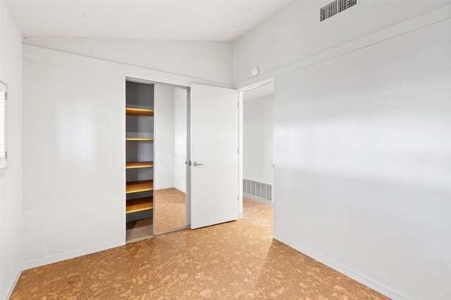 1703 E Barbara St, Tyler, TX 75701 - unfurnished bedroom with tile patterned floors, vaulted ceiling, a closet, and baseboards