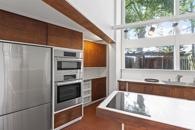 1703 E Barbara St, Tyler, TX 75701 - kitchen with stainless steel appliances, a sink, light countertops, and brown cabinetry