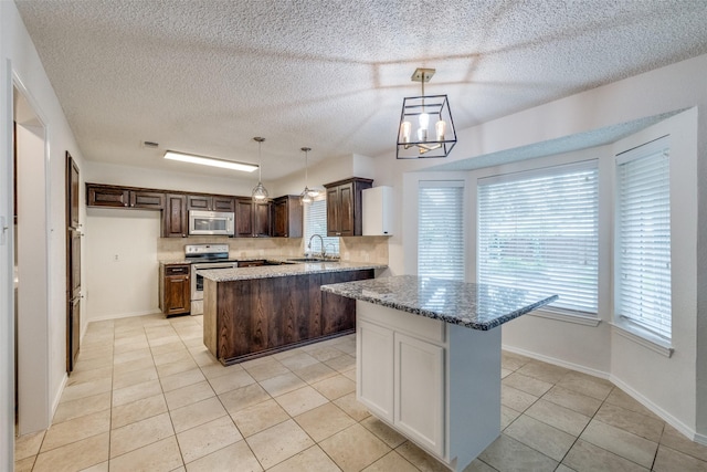 2505 Blue Quail Dr, Arlington, TX 76017 - kitchen featuring stainless steel appliances, a center island, a sink, healthy amount of natural light, and a textured ceiling