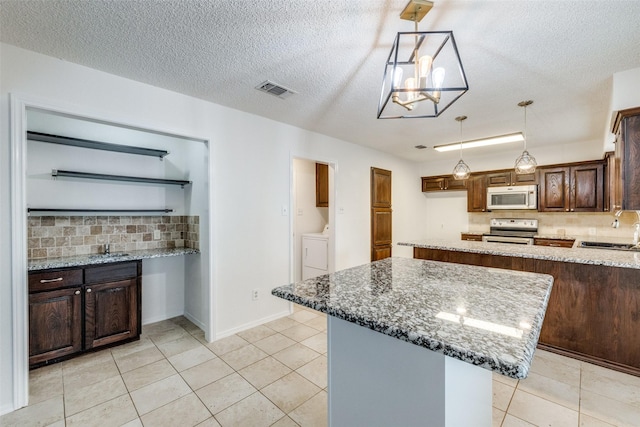 2505 Blue Quail Dr, Arlington, TX 76017 - kitchen featuring white microwave, stainless steel electric range, a sink, decorative backsplash, and a textured ceiling