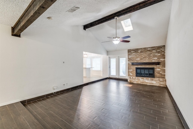 2505 Blue Quail Dr, Arlington, TX 76017 - unfurnished living room featuring dark wood finished floors, a fireplace, baseboards, a ceiling fan, and a skylight